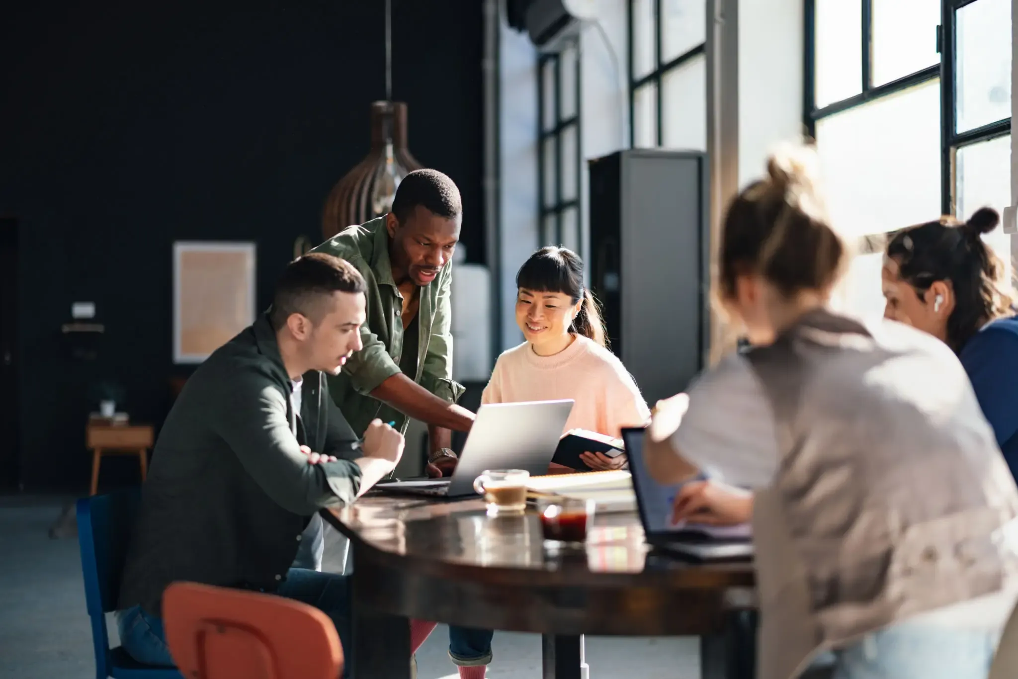 Team collaborating around a table in a modern office.